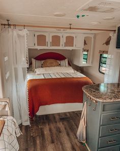 a bedroom with a bed, dressers and cabinets in the corner next to a window