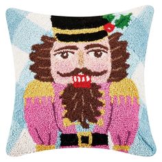 a decorative pillow with an image of a nutcracker wearing a top hat and holding a holly berry