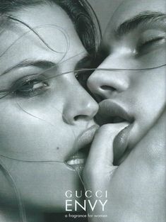 an advertisement for gucci envy perfume with two women kissing each other