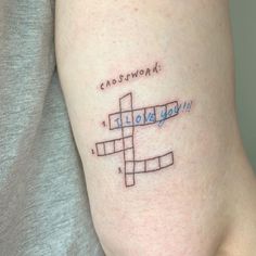 a person with a crossword tattoo on their leg