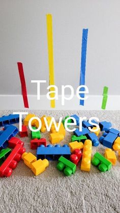 a pile of colorful legos sitting on top of a white carpet next to a wall