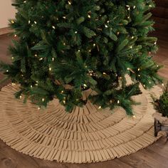 a small christmas tree in a wicker basket with lights on the top and bottom