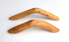 two long wooden objects on a white surface