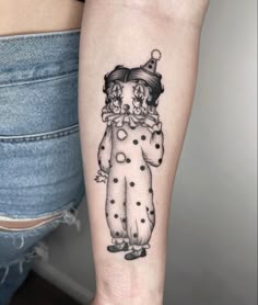 a woman's leg with a tattoo of a clown wearing a top hat and polka dots