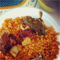 a white plate topped with rice and meat