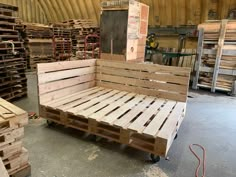 a bed made out of wooden pallets in a warehouse