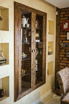 a wooden cabinet sitting next to a brick wall in a living room filled with furniture