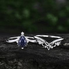 two engagement rings, one with a blue sapphire and the other with white diamond accents