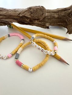 Teacher Appreciation Gift Bracelet Cute Teacher Gift Pencil Personalized Gift  A special gift for your favorite teacher! You can select the teacher name with two smaller pencils on either side, No 2 pencil or teacher bracelet. Listing is for a single bracelet.  Your teacher is sure to treasure this fun piece of jewelry. ♥ Created using polymer clay beads, gold plated anti tarnish gold beads, white beads with gold lettering and elastic string.  Each item is packaged in a little jewelry pouch  & r Teacher Bracelet, Cute Teacher Gifts, No 2 Pencil, Single Bracelet, Bracelet Cute, Gift Bracelet, Clay Bracelet, Favorite Teacher, Gold Lettering