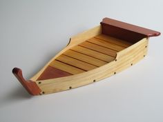 a wooden toy boat on a white surface