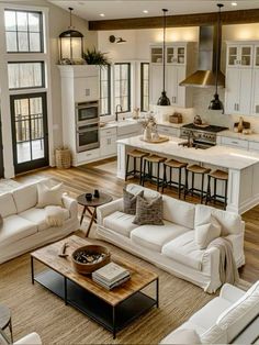 a living room filled with furniture next to a kitchen