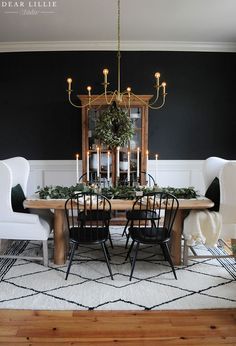 a dining room with black walls and white chairs