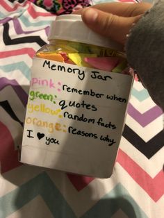 someone is holding a jar full of gummy bears in front of a colorful blanket