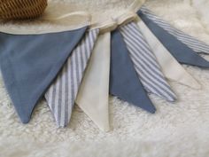 several blue and white striped ties laying on top of a blanket next to a basket