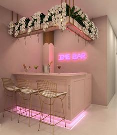 the bar is decorated with white flowers and pink neon lights, along with four chairs