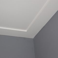 the corner of a room with a white ceiling and gray walls is shown in this image