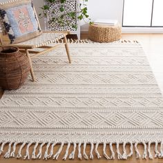 a white rug with fringes on the floor in front of a chair and potted plant