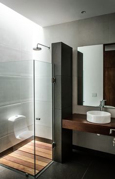 a bathroom with a sink, mirror and shower stall