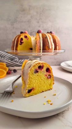 a piece of cake on a plate with a fork next to it and an orange slice in the background