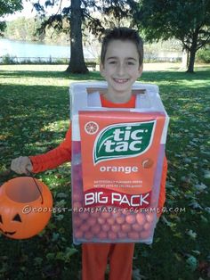 a young boy in an orange halloween costume holding a trick or treat bag