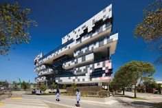 two people walking in front of a building that is designed to look like cubes