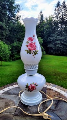 a white vase sitting on top of a stone table