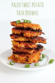 four fried potato hash browns stacked on top of each other with green onions in the middle