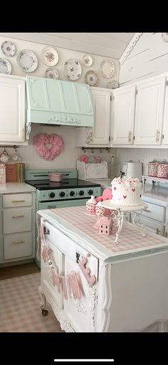 a kitchen with white cabinets and pink decorations