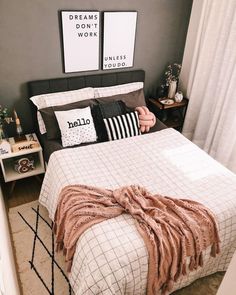 a bed in a bedroom with two pictures on the wall above it and a throw blanket