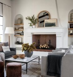 a living room filled with furniture and a fire place in the middle of a room