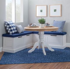 a white table with blue cushions on it and a bench in the corner next to it