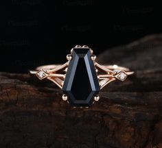 an elegant black diamond ring on top of a tree branch with diamonds in the middle