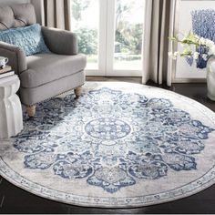 a blue and white rug in a living room next to a chair with a vase on it