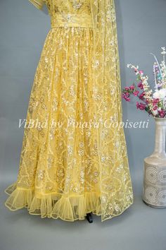 Effortlessly elegant, this Yellow Net Embroidered One Side Cape Sleeve Gown boasts a stunning petal embellished sleeve on one side and a chic waist belt. Perfect for special occasions, it offers a flattering fit and intricate details for a truly sophisticated look. Side Cape, Net Gowns, Sleeve Gown, Cape Sleeves, Gowns With Sleeves, The Net, One Sided, Intricate Details, Waist Belt