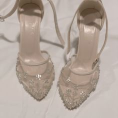 a pair of high heeled shoes with beading on them