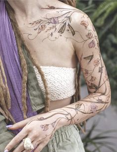 a woman with tattoos on her arms and chest