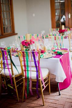 the table is set with colorful ribbons and place settings