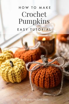 crochet pumpkins sitting on top of a wooden table