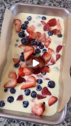 a pan filled with strawberries and blueberries on top of a counter