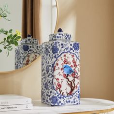 a blue and white canister sitting on top of a table next to a mirror