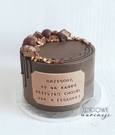 a cake with chocolate frosting and decorations on it's top is decorated with a tag that says grzegoffi, 40 na kars