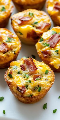 mini bacon and cheese quiche cups on a white plate with parsley sprigs