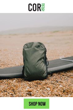 a surfboard laying on the ground next to a bag that is sitting on top of it