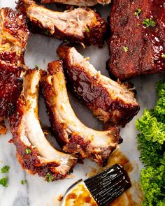 barbecue ribs and broccoli on a plate with a spatula next to them