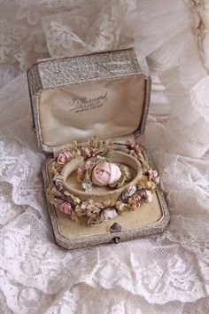 an antique trinket in a box on a lace tablecloth