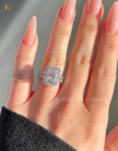 a woman's hand with an engagement ring on it