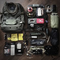 the contents of a travel bag laid out on top of a wooden floor next to each other