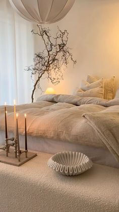 a bed with candles on the side and a tree in the corner next to it