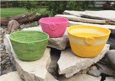 three woven baskets sitting on top of rocks