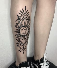 a woman's leg with a sun tattoo on it